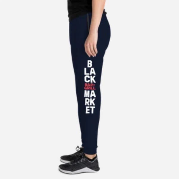 Person wearing navy blue Black Market Bar + Grill sweatpants with white and red lettering.