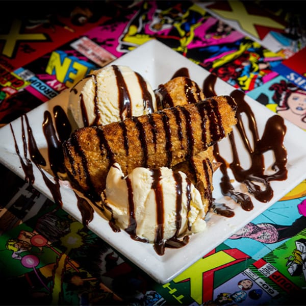 Fried dessert with vanilla ice cream and chocolate syrup on a comic book background.
