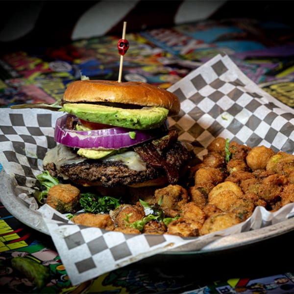 Black Market Bar and Grill's burger with avocado, red onion, cheese, and bacon, served with fried okra.